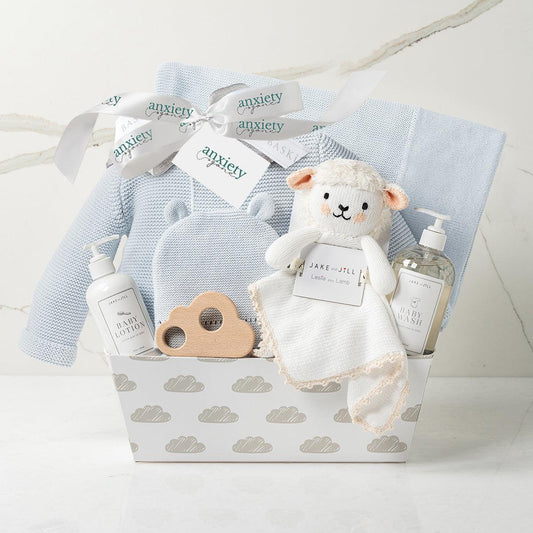 Baby boy gift basket in blue with clothing, blanket, and plush is aLuxury newborn gift set for boys with hat, sweater, lovie, and teether