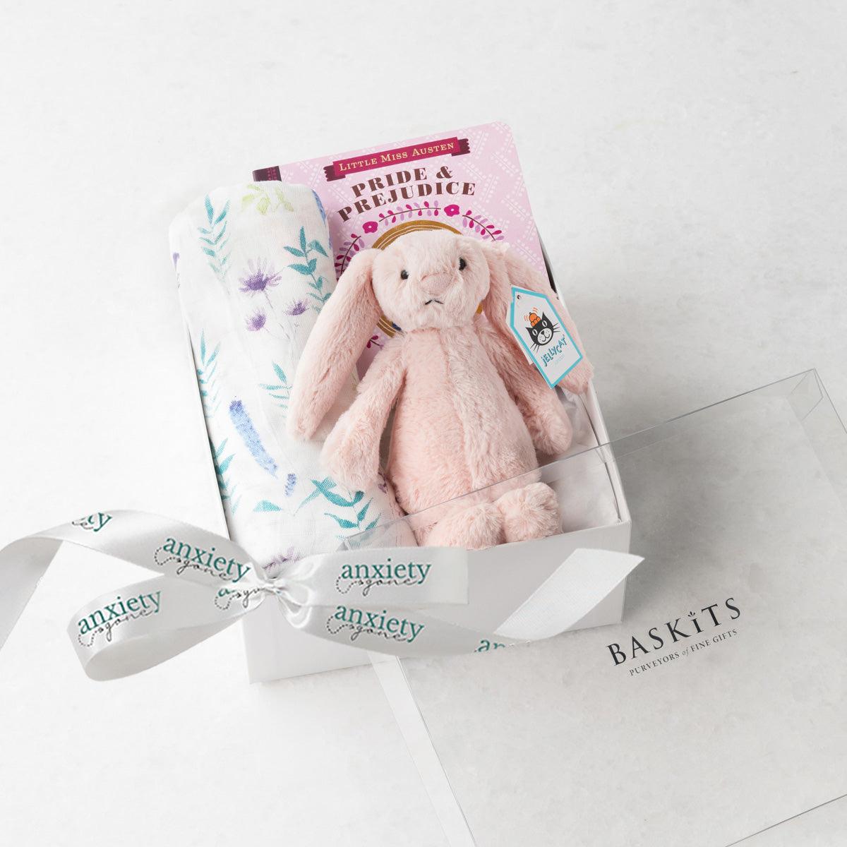 Pink new baby girl gift basket with swaddle, bunny, book, and teether, making it the perfect Bedtime snuggles gift set for newborn girls in keepsake box