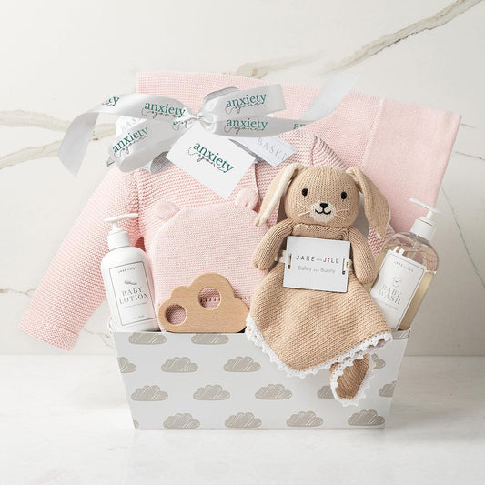 Baby girl gift basket in pink with clothing, blanket, and plush is a Luxury newborn gift set for girls with hat, sweater, lovie, and teether