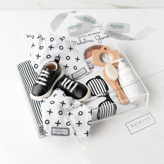 Baby boy gift basket with swaddle, onesie, shoes, and teether is a Stylish newborn gift set for boys with clothing and keepsakes

