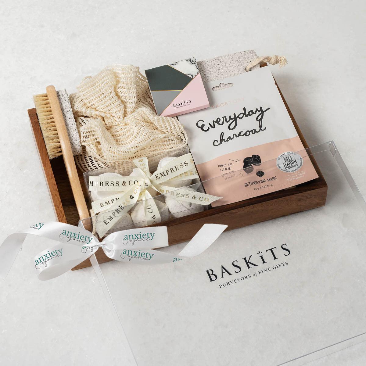 Spa Essentials Wellbeing Gift Box featuring luxurious self-care items like lavender bath bombs, face masks, foot care products, and a wooden tray—perfect for self-care gifts, spa gift baskets, and mental health gifts.