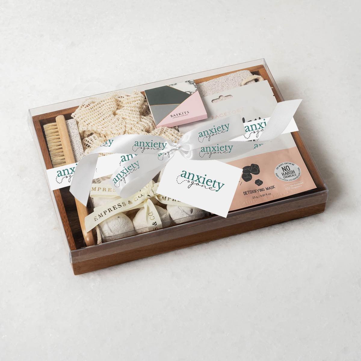 Spa Essentials Wellbeing Gift Box featuring luxurious self-care items like lavender bath bombs, face masks, foot care products, and a wooden tray—perfect for self-care gifts, spa gift baskets, and mental health gifts.