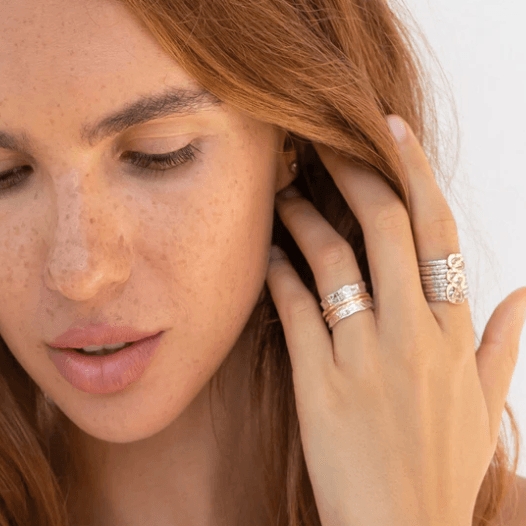 Sterling Silver Fidget Ring with Yellow Gold accent swirl bar and nine hammered silver spinning bands, displayed with complimentary MeditationRings Tin and Travel Pouch