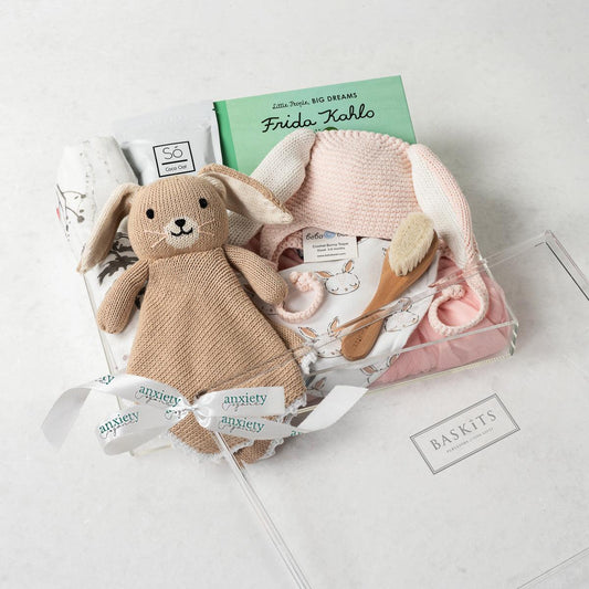 Bunny-themed newborn girl gift set with book and bath items for a Personalized baby girl gift basket with clothing, toys, and book