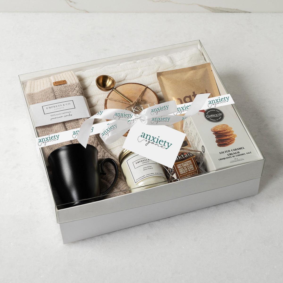 Keeping It Cozy Gift Collection featuring premium self-care items like a cable knit blanket, gourmet treats, coffee, and candles—perfect for self-care gifts, get well soon gifts, and thank i gift baskets.