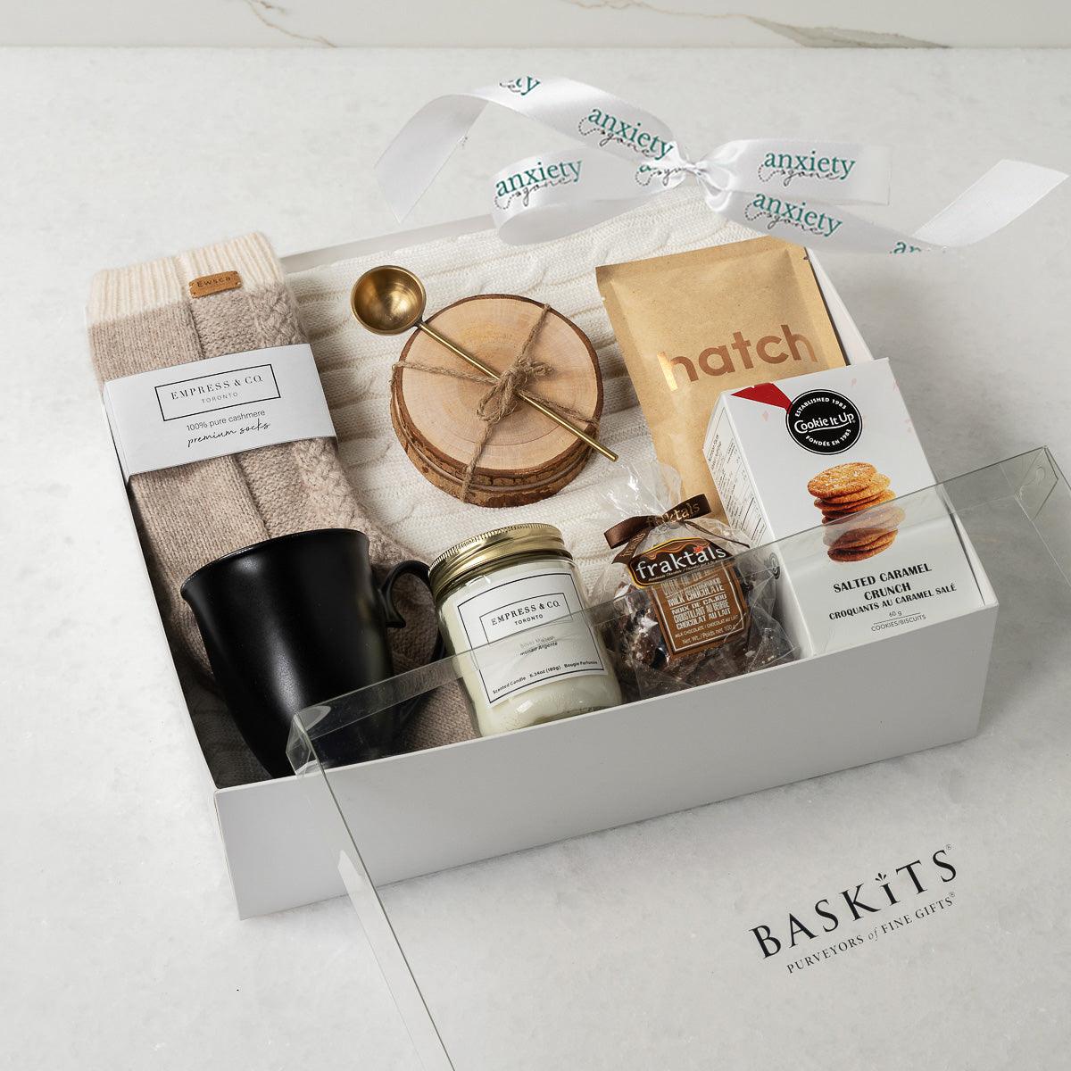 Keeping It Cozy Gift Collection featuring premium self-care items like a cable knit blanket, gourmet treats, coffee, and candles—perfect for self-care gifts, get well soon gifts, and thank i gift baskets.